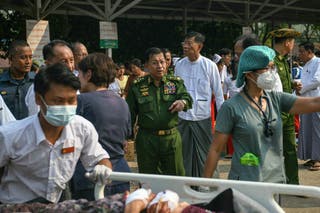 Myanmar's military chief Min Aung Hlaing gestures as earthquake survivors gather in the compound of a hospital in Naypyidaw